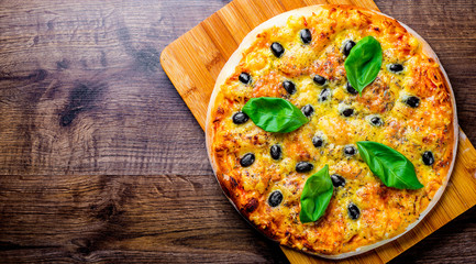Pizza with Mozzarella cheese, Tomatoes, pepper, olive, Spices and Fresh Basil. Italian pizza. Pizza Margherita or Margarita on wooden table background