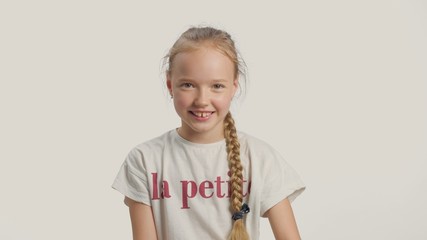 Young girl in studio watching to the camera and smiling