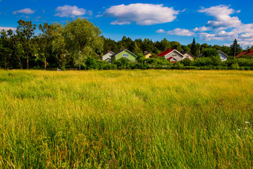 Colorful wooden homes nestled among lots of greenery in a suburb of Turku, Finland.	