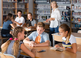 Obraz premium Young boys and girls brainstorming in teams