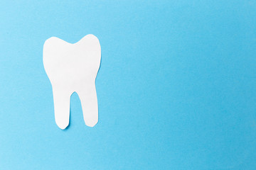 Concept of dental care represented by a tooth with a black part on blue background. Medical teeth protection and hygiene symbol. Healthy dentistry concept.