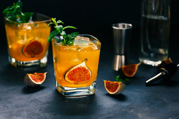 Summer cool cocktail from tonic, gin with figs, ice and mint. Summer party or detox concept