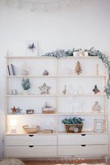 Christmas decorations. Cozy interior in pastel colors. Christmas tree and star figures on a shelf. Multi-colored bokeh in the background
