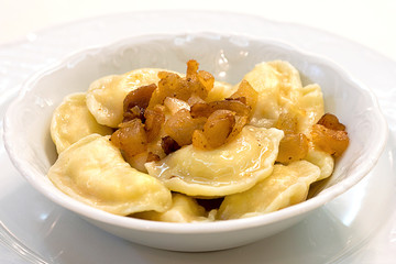 dumplings with greaves on a white plate, hearty meal, a traditional dish of Slavic cuisine