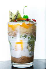 vertical view on original fruits and cream dessert in tall glass