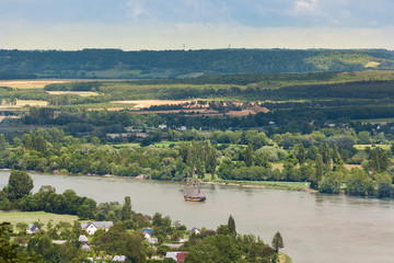 Naklejka premium Tall ship Shtandart sailing on the Seine River, through green lush countryside, Armada 2019, Normandy, France