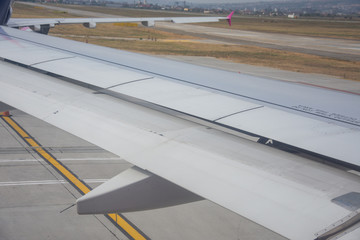 An airplane window view of wing and flaps 