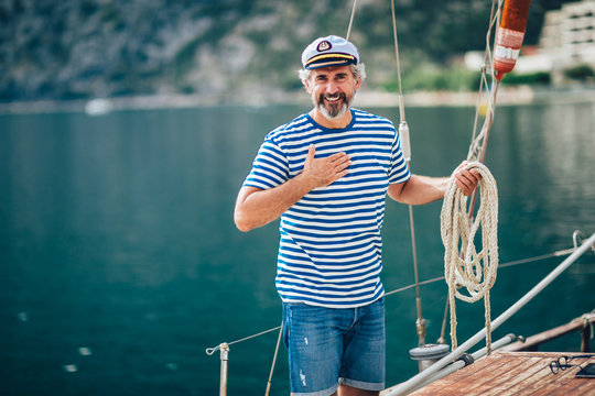 Portrait of senior man tying knot and securing a mooring for his hobby yacht sail boat