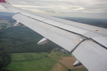 An airplane window view of wing and flaps 