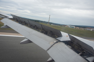 An airplane window view of wing and flaps 