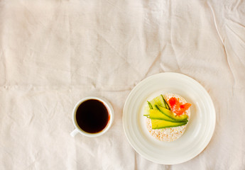 Rice crispy cakes with avocado and fresh salted salmon. Cup of coffee. Top view. Space for text. High protein and low carbohydrate meal. White linen tablecloth background