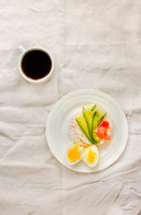 Rice crispy cakes with avocado and fresh salted salmon. Cup of coffee. Top view. Space for text. High protein and low carbohydrate meal. White linen tablecloth background