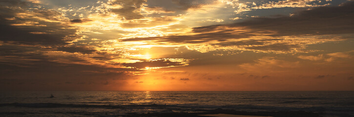 beautiful orange sunrise with fishing boat and clouds