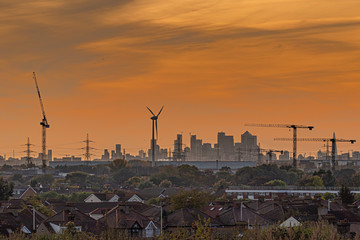Sunset over city view with industrial cranes