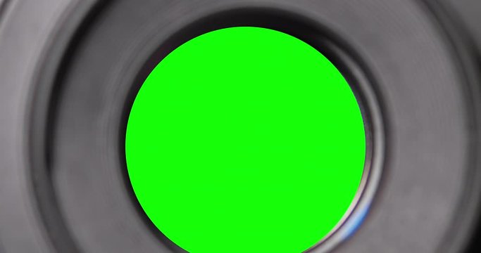 Diaphragm blades of the fixed lens opening and closing aperture f-stop adjustment of a photo camera close-up shot with green chroma key