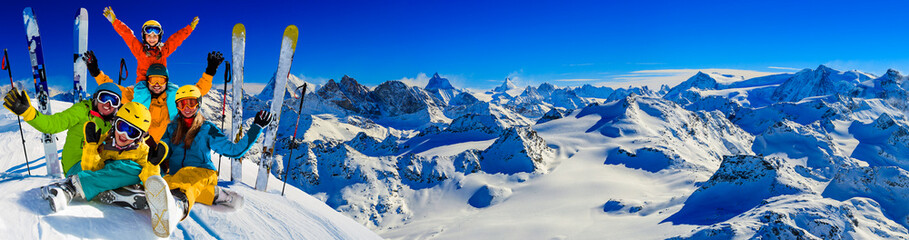 Happy family enjoying winter vacations in mountains . Ski, Sun, Snow and fun. - obrazy, fototapety, plakaty