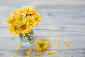 床の上のガラス瓶に入った黄色い花