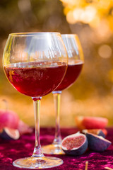 Two glasses of red wine on an autumn picnic. Fruits, sweets, nuts.