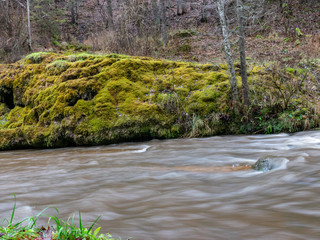 foggy image of a steep river and mossy coastline, the texture of the water gives the feeling of something soft