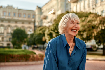 Don't stop laughing! Beautiful senior woman in casual wear smiling and feeling happy while standing outdoors on a sunny day