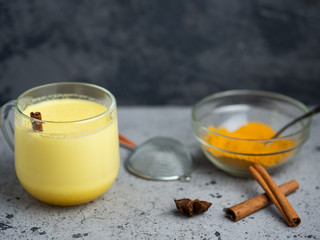 Indian spice turmeric Golden milk in a mug on a dark stone table