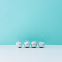 Winter holidays composition. Silver decorations on white and blue background. Christmas and new year concept. Layout still life, copy space