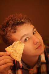 teen boy eats pizza and enjoys it, closeup enjoying and savoring.