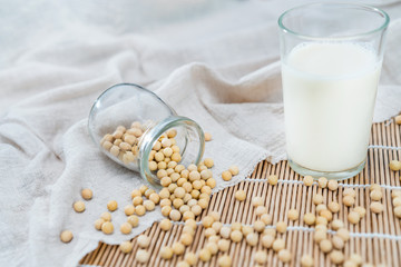 Many soybeans and a cup of soymilk on the bamboo mat