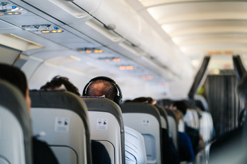 man listens to music in headphones on a plane