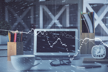 Financial chart drawing and table with computer on background. Multi exposure. Concept of...