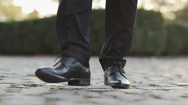 Closeup of luxury shoes, businessman walking, elegant rich person. Man in black shoes stepping forward Person moving forward outdoor.