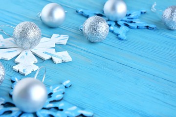New Year 2020 flat lay with wooden snowflakes and silver sparkle decorative ball on blue textured background, selective focus. Christmas and New Year flat lay with shiny decorations on blue backdrop 