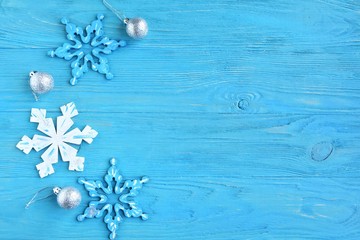 New Year 2020 flat lay with wooden snowflakes and silver sparkle decorative ball on blue textured background, selective focus. Christmas and New Year flat lay with shiny decorations on blue backdrop 