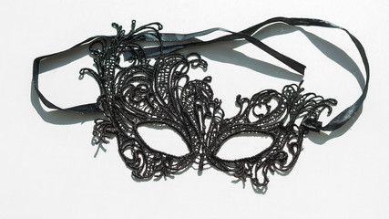 Black lace masquerade mask on a white background