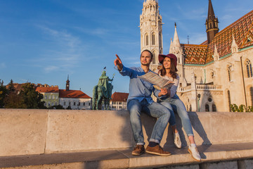 Young couple searching right direction on map from the point from Fisherman Bastion in Budapest...