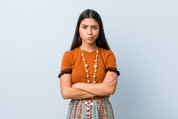 Young arab woman frowning face in displeasure, keeps arms folded.