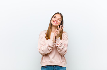 young pretty woman feeling happy and successful, smiling and clapping hands, saying congratulations...