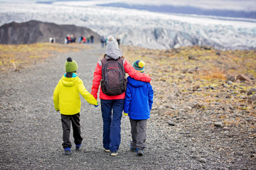 Mother walking with his children on a path towards Skaftafell Glacier national park on a gorgeous autumn day in Iceland © Tomsickova