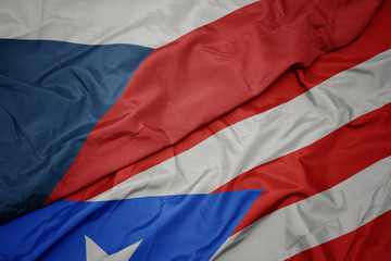 waving colorful flag of puerto rico and national flag of czech republic.