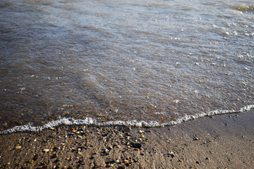 Soft wave of the sea on the sandy beach. pure transparent waves beat on the sandy shore.