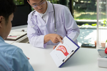 Doctor consultation Patient about  blood vessel with explain model of blood vessel on clipboard in...