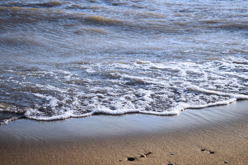 Soft wave of the sea on the sandy beach. pure transparent waves beat on the sandy shore.