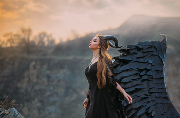 Fantasy lady in a black dress with huge wings. Demon with horns. Dark gothic fashion glamorous...