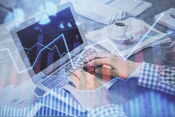 Double exposure of forex chart with man working on computer on background. Concept of market analysis.