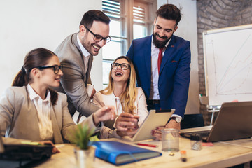 Business colleagues working on laptop in modern office.