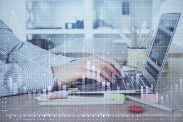 Double exposure of stock market graph with man working on laptop on background. Concept of financial analysis.