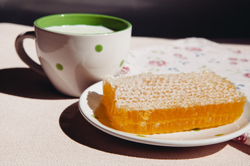 Honeycomb and milk on table, healthy organic food