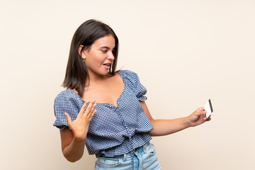 Young girl over isolated background holding a credit card