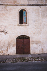 Naklejka premium old door in wall – Streets and doors of Puglia, Italy