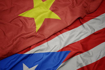 waving colorful flag of puerto rico and national flag of vietnam.